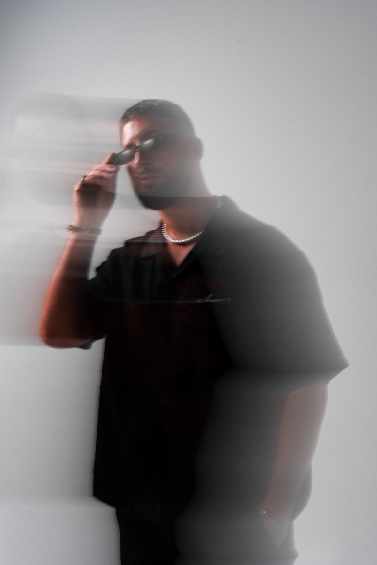 Motion-blur portrait adjusting sunglasses