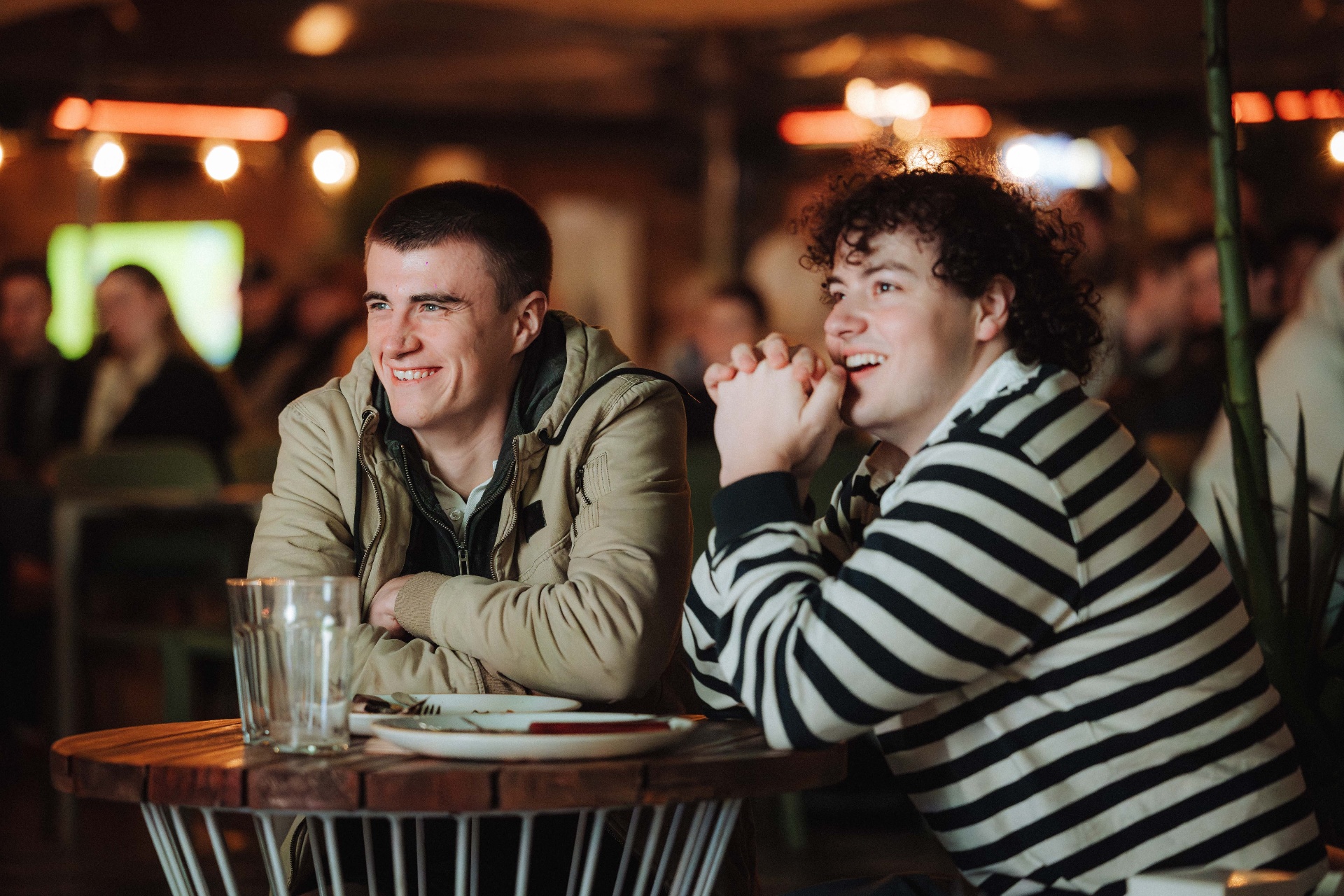 Two friends laughing at a pub table