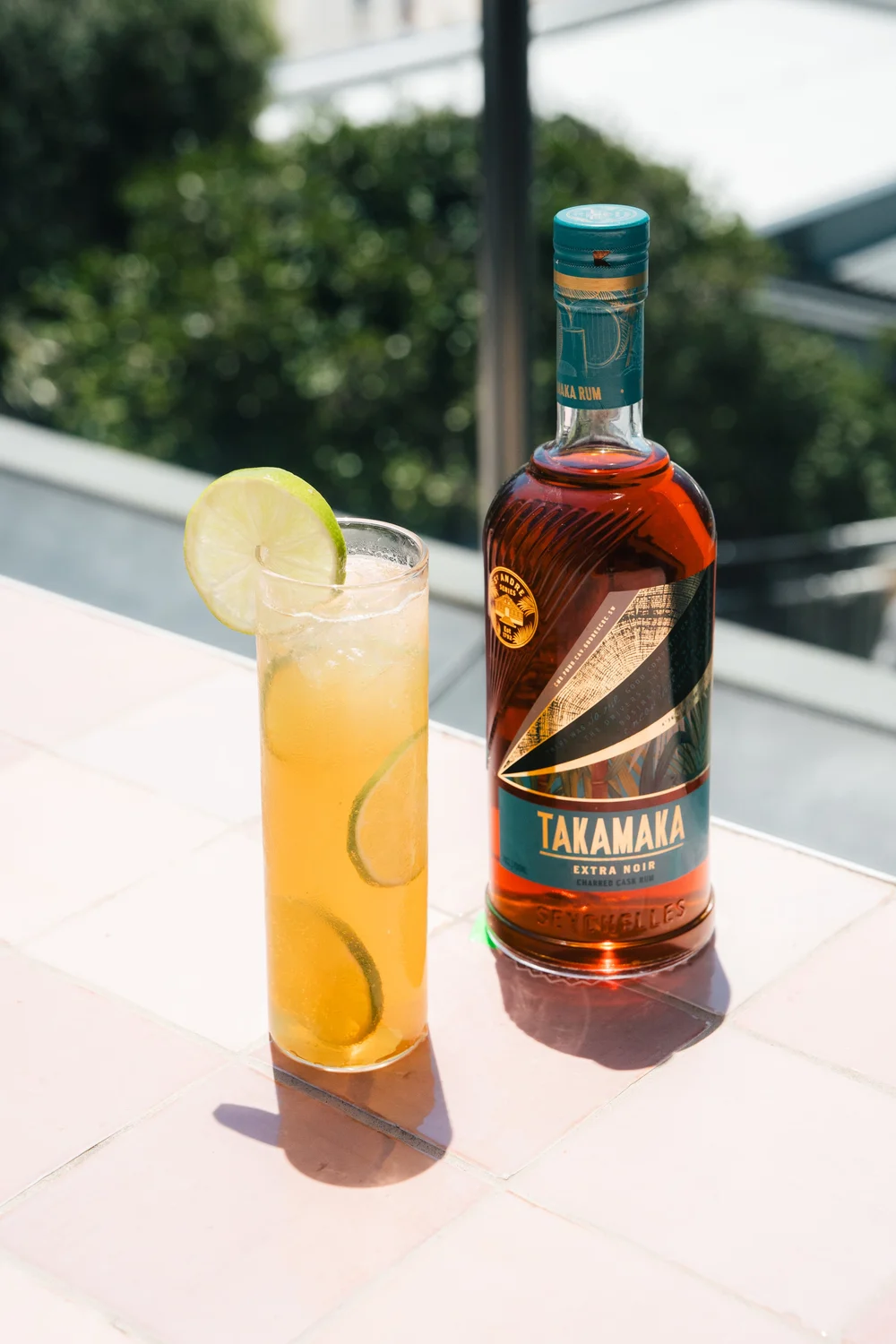 Takamaka Extra Noir rum bottle with highball cocktail