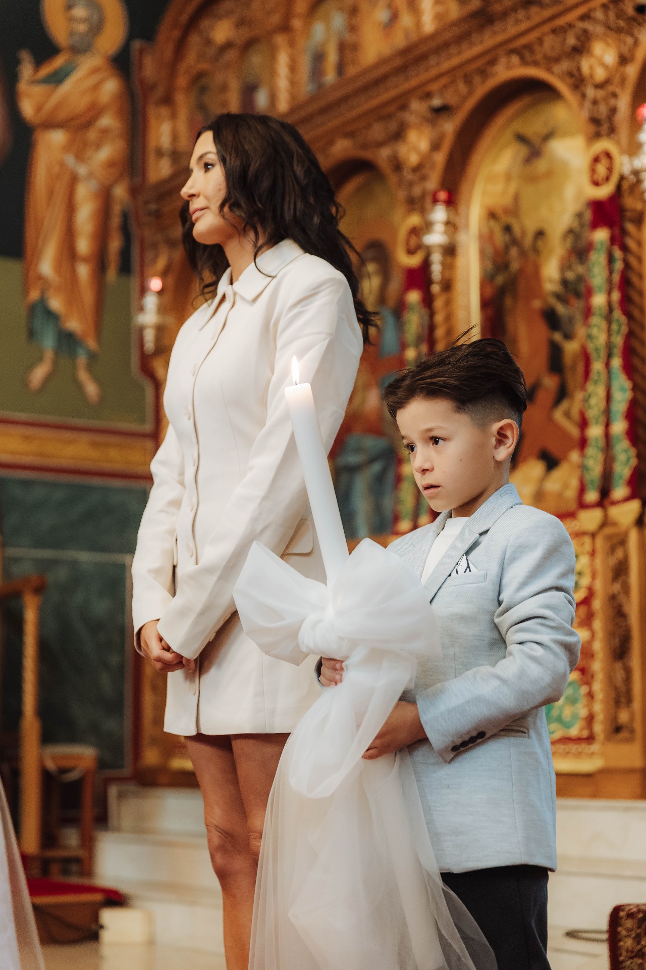 Godmother and child holding baptism candle