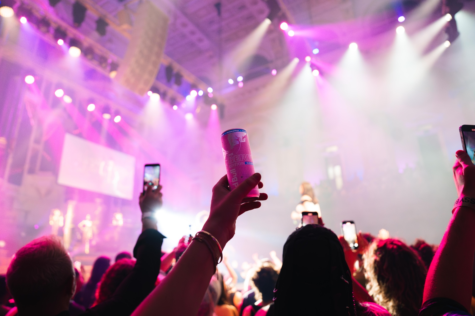 Crowd holding Red Bull Berry can under stage lights