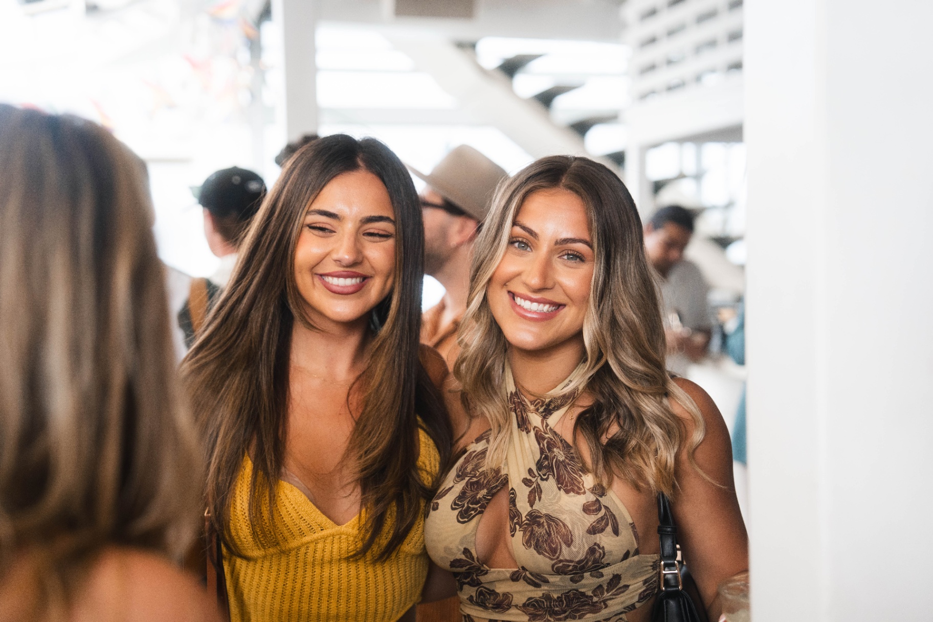 Two guests smiling at Takamaka x The Island event