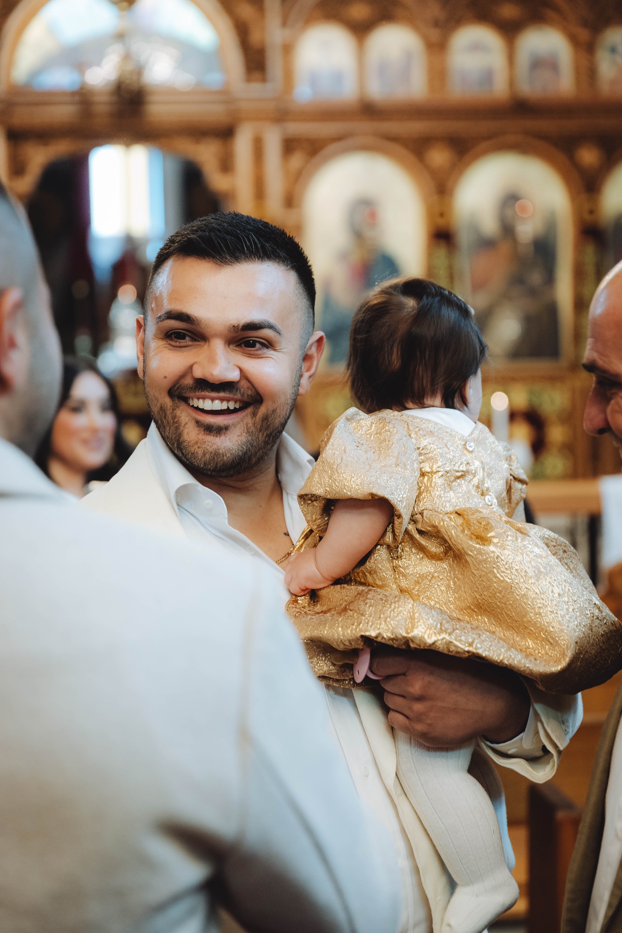 Father smiling with baby at christening